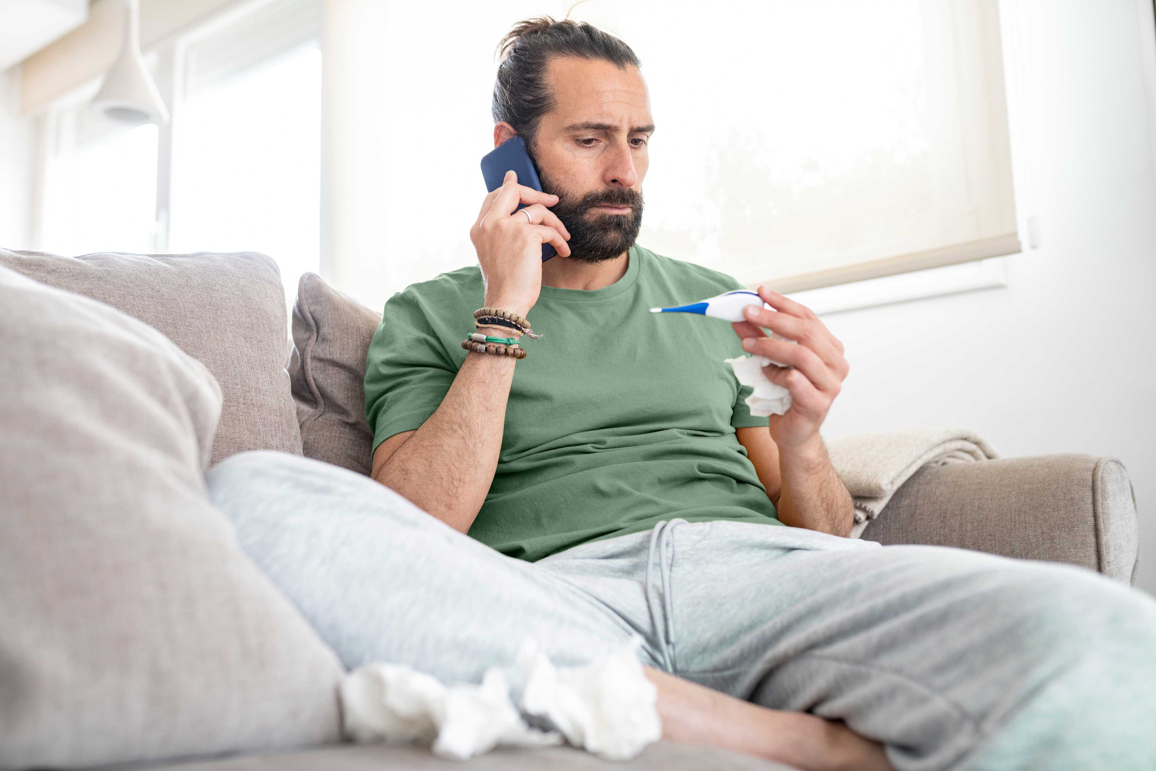 Gesundheit_Mann_Krank_Sofa_Telefon_Fiebermesser_s