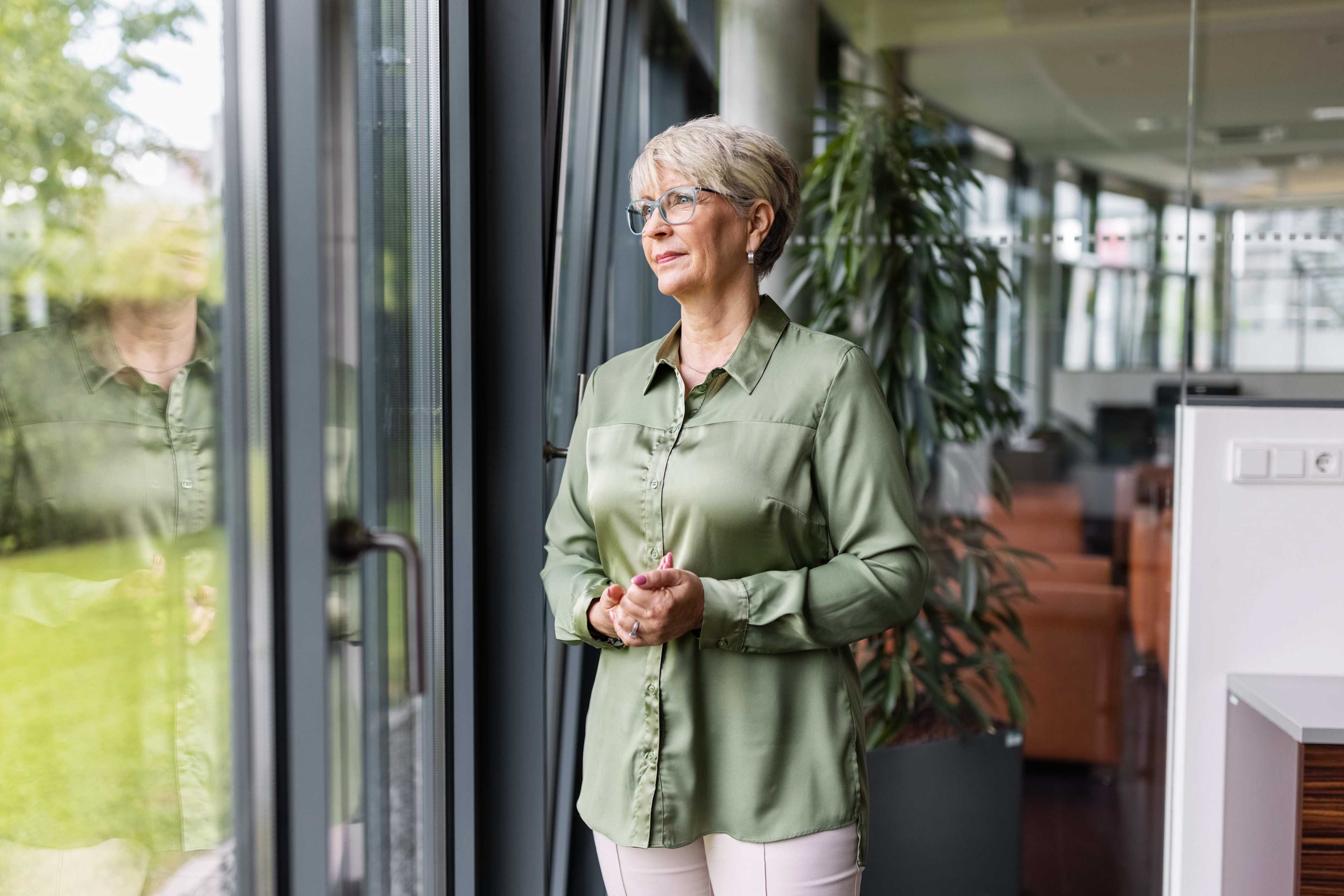 Employer_Brand_Frau_Fenster_nachdenklich_s_rb3gnc