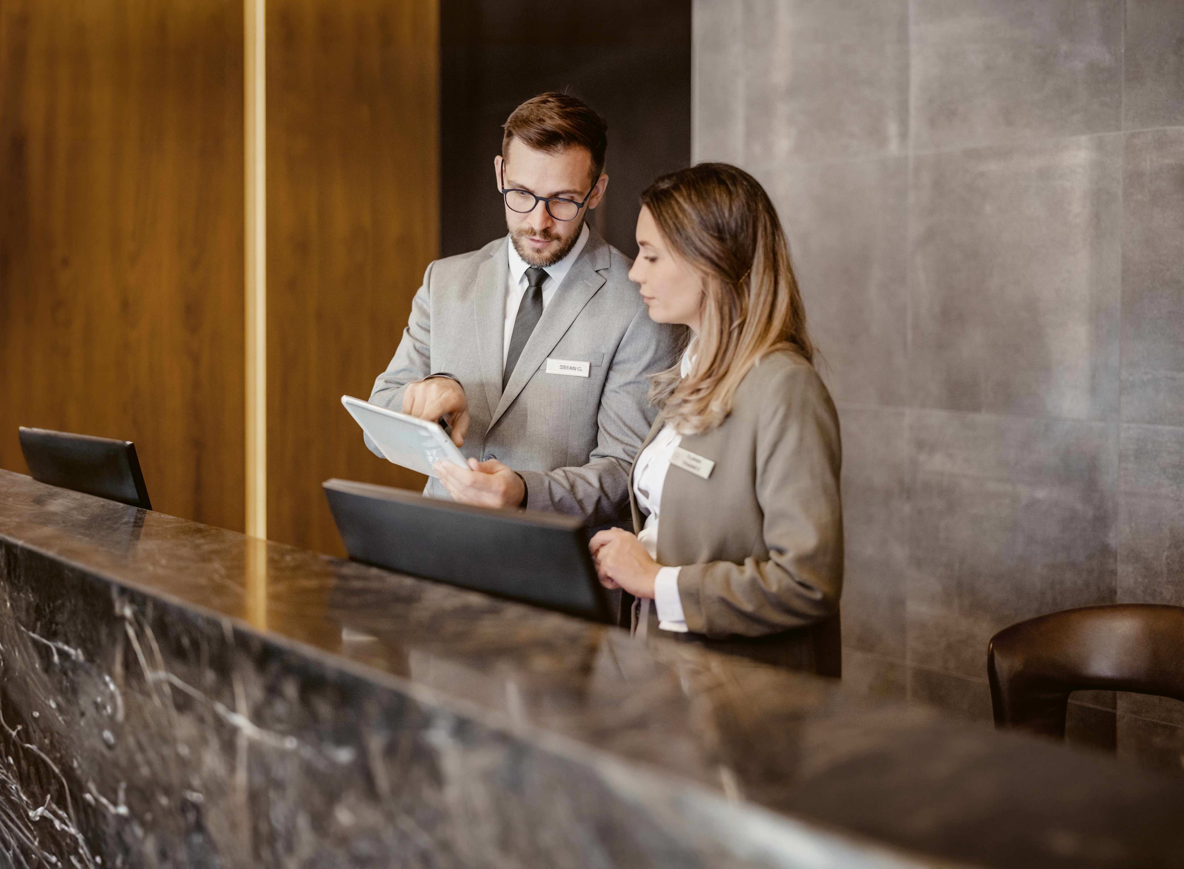 Business_Hotel_Rezeption_Mitarbeitende_Erklaeren_s_vyjysw